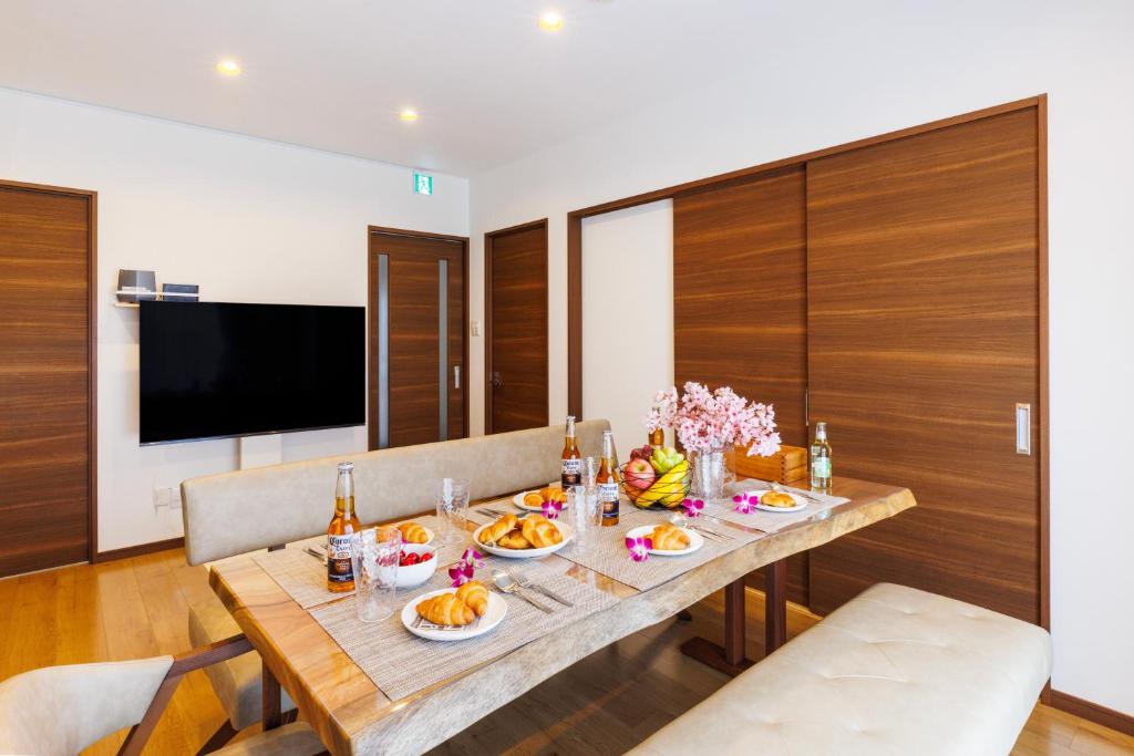 un comedor con una mesa con comida. en Tsubaki house, en Yomitan