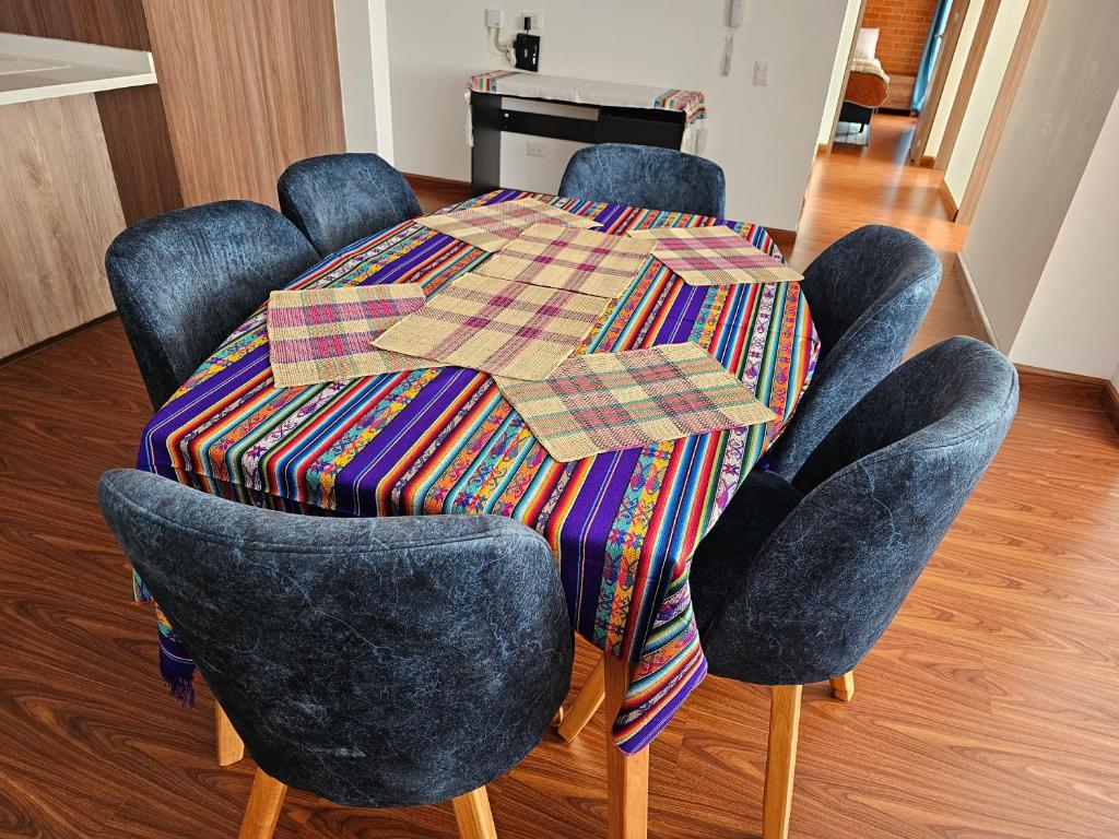 una mesa con cuatro sillas y un mantel en ella en centro de pasto apartamento kz, en Pasto
