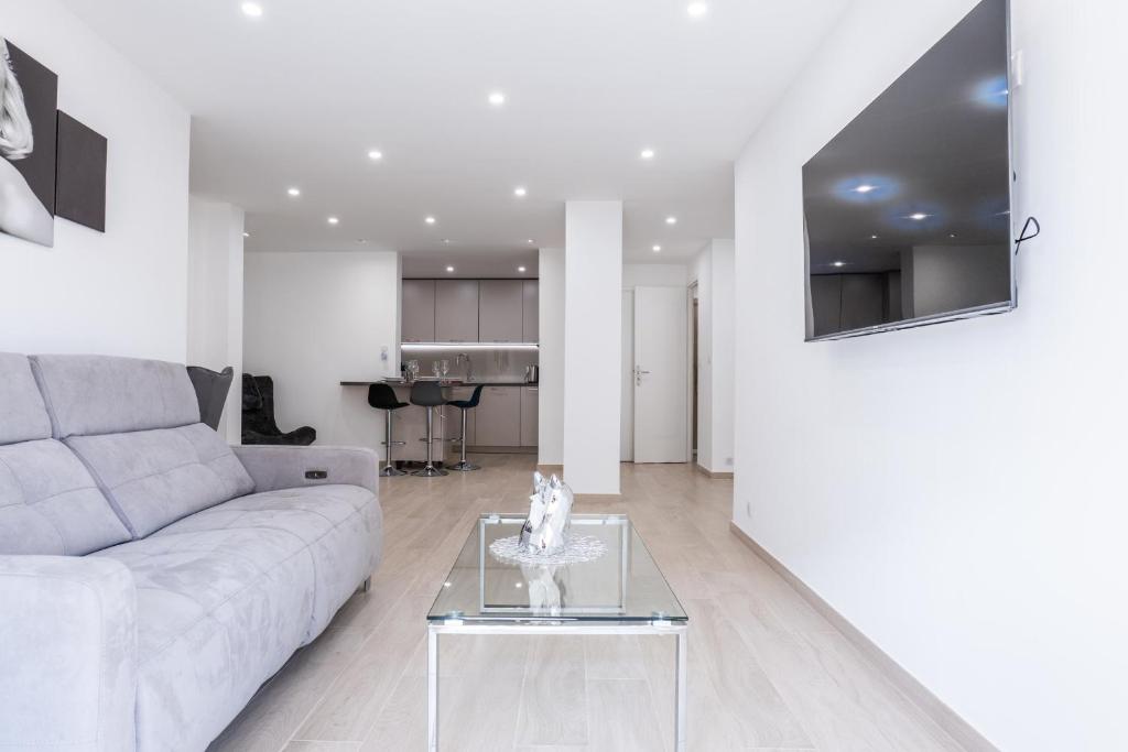 un salon avec un canapé et une table dans l'établissement 2 bedrooms with terrace 100 metres from the sea, à Cannes