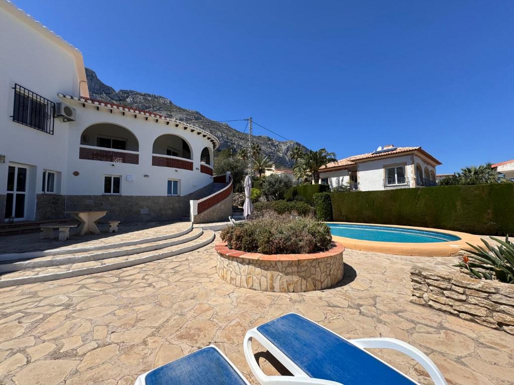 德尼亞的住宿－Villa Clara，一座带两把蓝色椅子的房子和一个游泳池