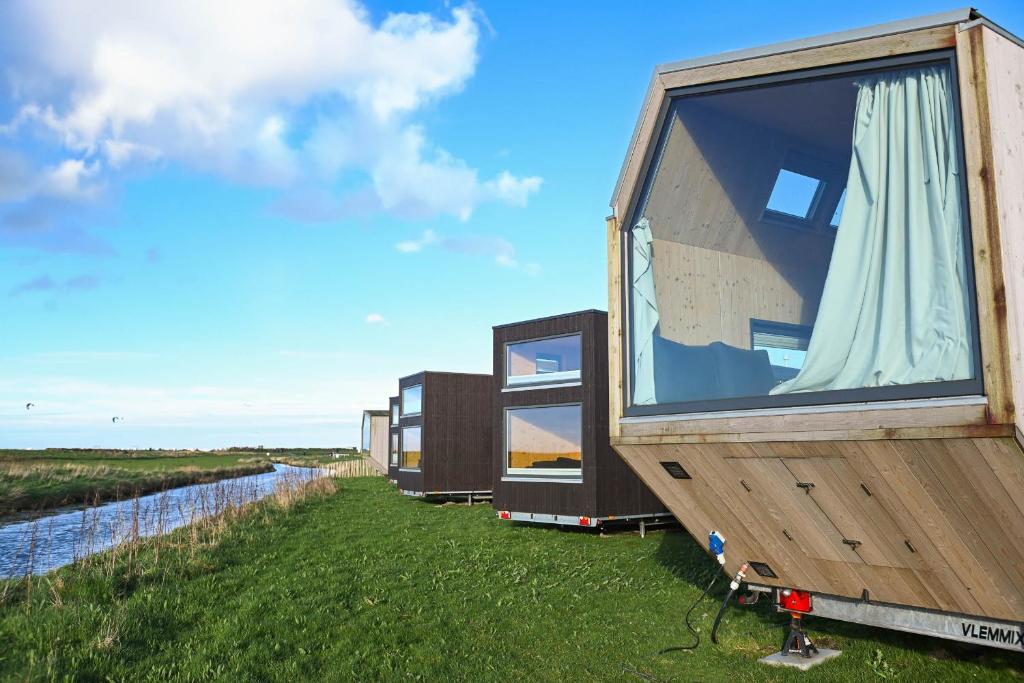 a row of modular houses sitting on the grass at Tiny House Pioneer 17 Zur Meerseite - Green Tiny Village Harlesiel in Carolinensiel