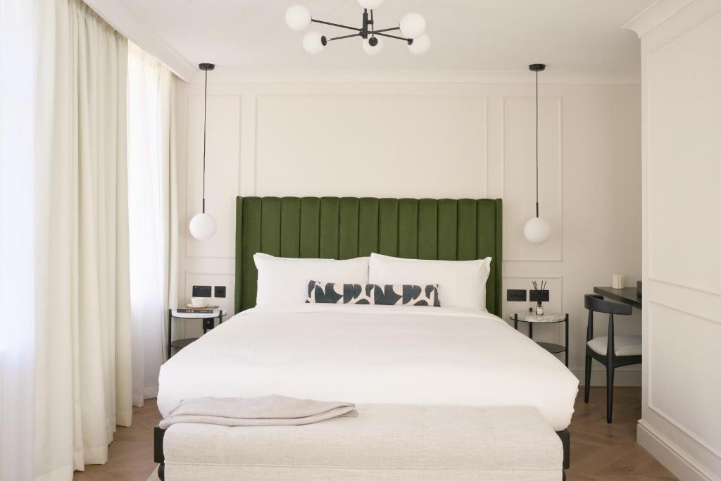 a bedroom with a large white bed with a green headboard at The Store in Oxford