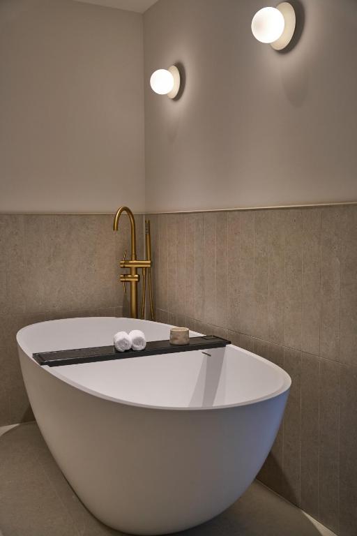 a white bath tub in a bathroom with two lights at The Store in Oxford