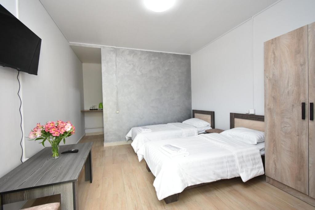 a bedroom with two beds and a table with flowers at SIRIK in Armavir