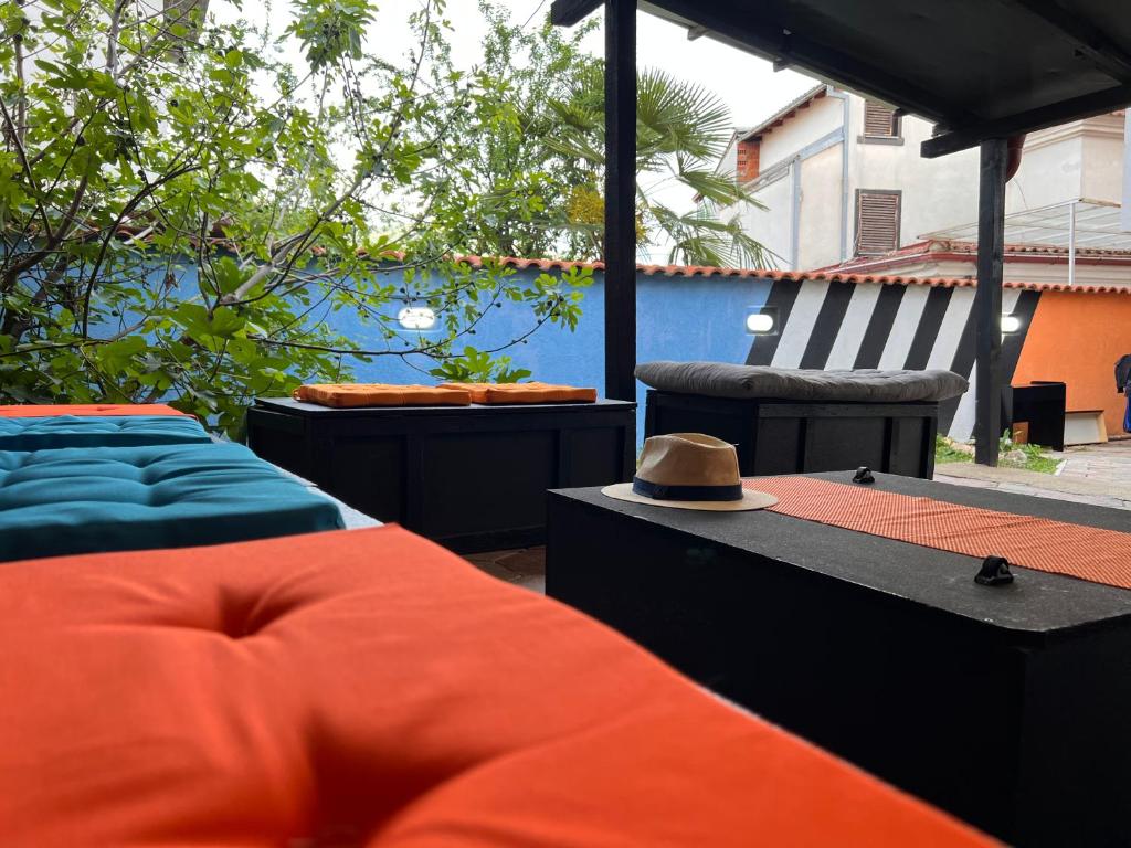 Blue Orange Lake Hostel في أوخريد: فناء به سريرين وقبعة على طاولة