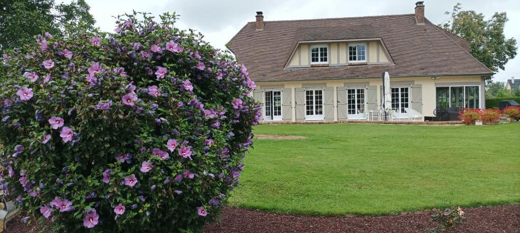 ein Haus mit rosa Blumen vor einem Hof in der Unterkunft HIBISCUS in Malaunay