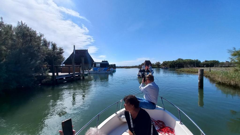 un groupe de personnes sur un bateau sur une rivière dans l'établissement Casa Martina "holiday home" Marano Lagunare, à Marano Lagunare