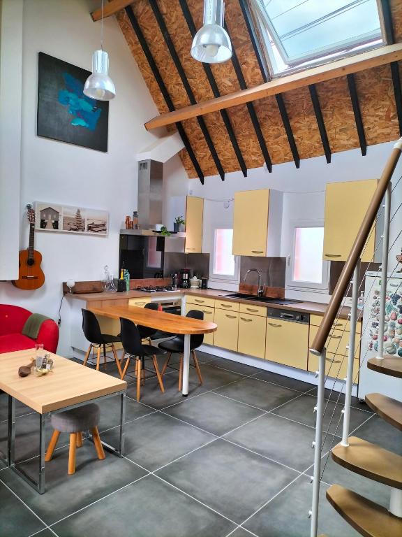 une grande cuisine avec une table et des chaises dans l'établissement Beach house, à La Turballe