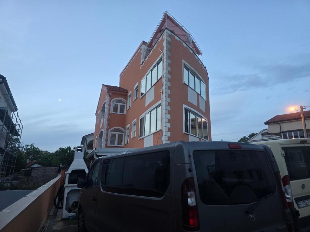 una furgoneta estacionada frente a un edificio en Apartments Vugica Šilo, en Šilo