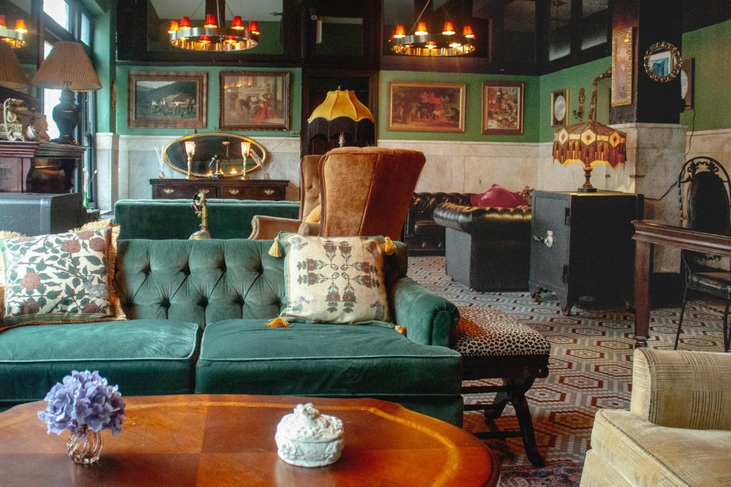 The Nolita Express Hostel في نيويورك: غرفة معيشة مع أريكة خضراء وطاولة