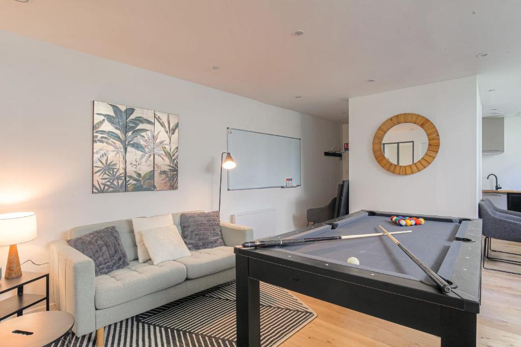 un salon avec une table de billard et un canapé dans l'établissement Cosy et Calme idéal déplacement pro, à Lyon