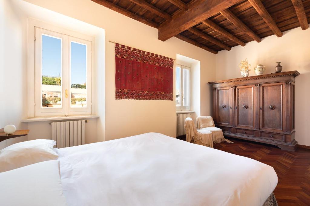 Un dormitorio con una gran cama blanca y una ventana en Trevi Comfortable Apartment with Terrace | Romeloft, en Roma
