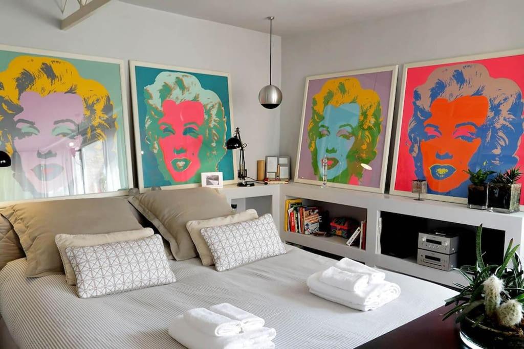 ローマにあるScala Luxury Terrace studioのベッド付きの部屋、壁に絵画が飾られています。