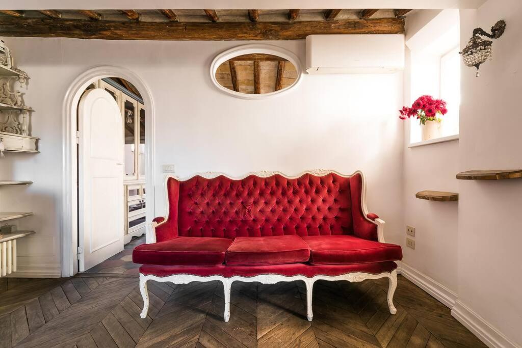 a red couch in a room with a mirror at Scala Lovely Terrace Apartment in Rome