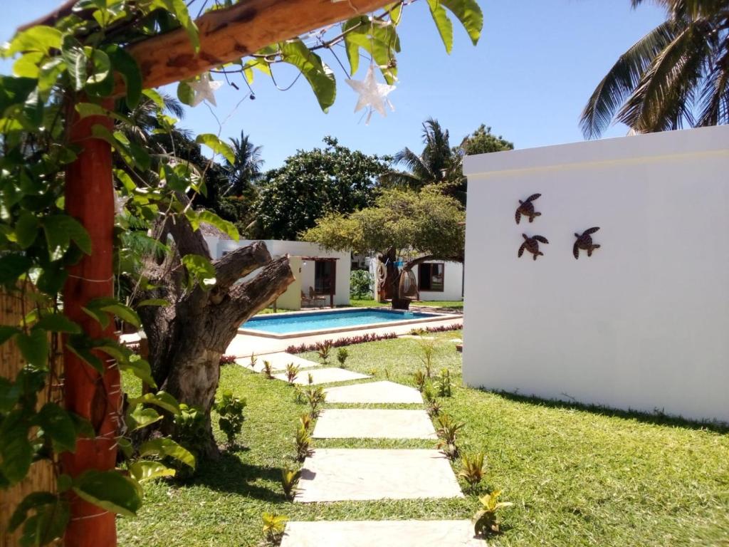 a wall with birds on it next to a swimming pool at Telvina Beach Lodge in Vilanculos