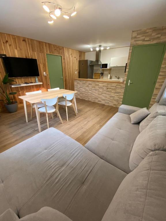 ein Wohnzimmer mit einem Sofa und einem Tisch in der Unterkunft Petit cocon comme a la maison in Villard-de-Lans