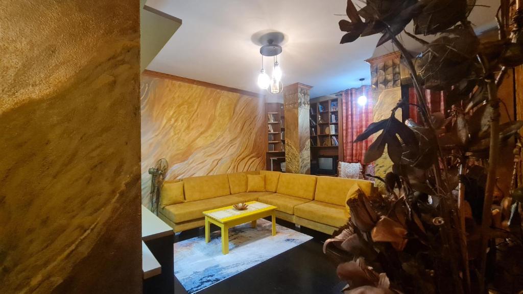 sala de estar con sofá amarillo y mesa en Top Shkodra location, en Shkodër