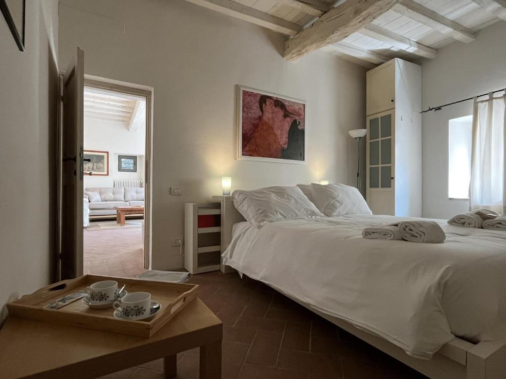 um quarto com uma grande cama branca e uma mesa em Your Terrace in Fiesole em Fiesole