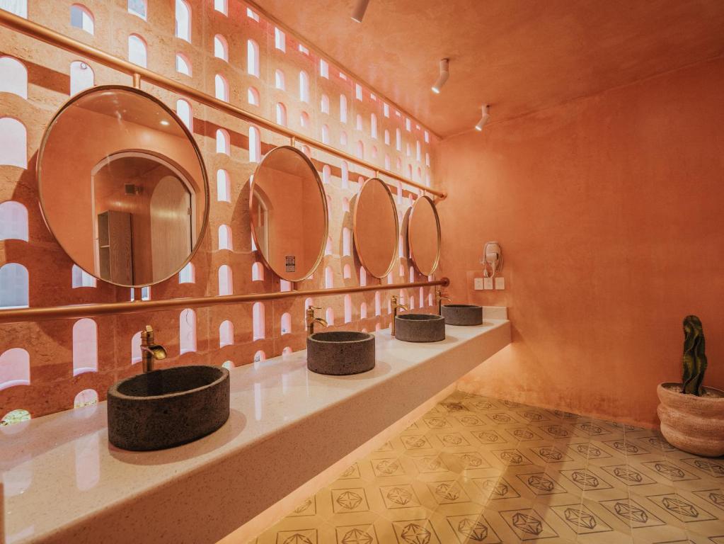 a row of sinks in a bathroom with mirrors at Casa Amate 61 Boutique Hostel in Mérida