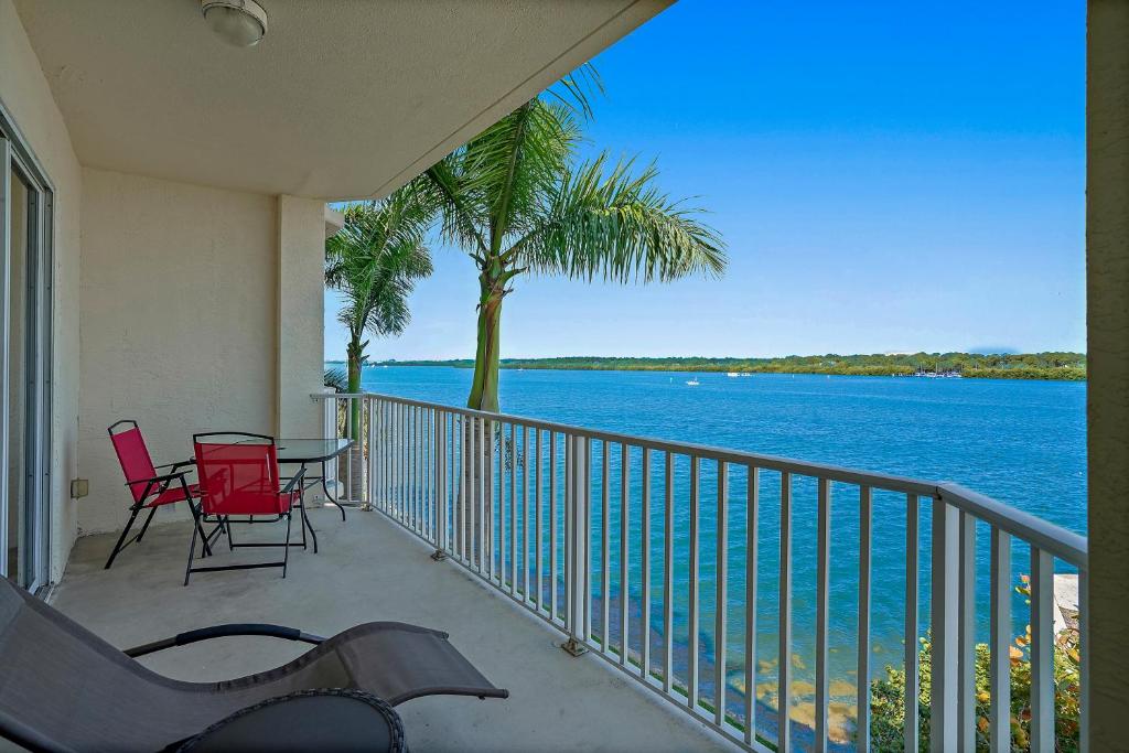 a balcony with a table and chairs and a view of the water at Oceanfront Luxury Condo! Mins to beach! Rum Bar Next Door! in St. Petersburg