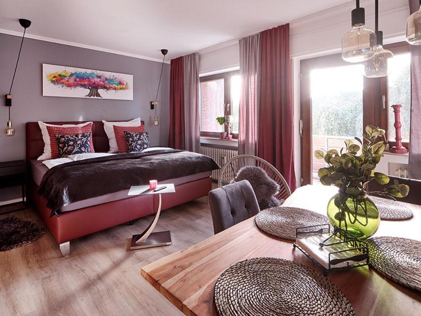 a bedroom with a bed and a dining room at KATARINAS HOUSE mit 2 FeWo stilvoll, gemütlich & zentral Boxspringbett, Parkplatz, Balkon oder Garten in Moers