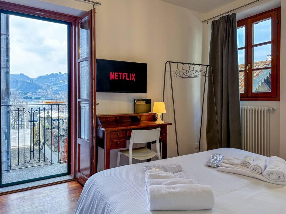 una camera con letto, scrivania e balcone di Como - Magic Garden House - Lake View a Como
