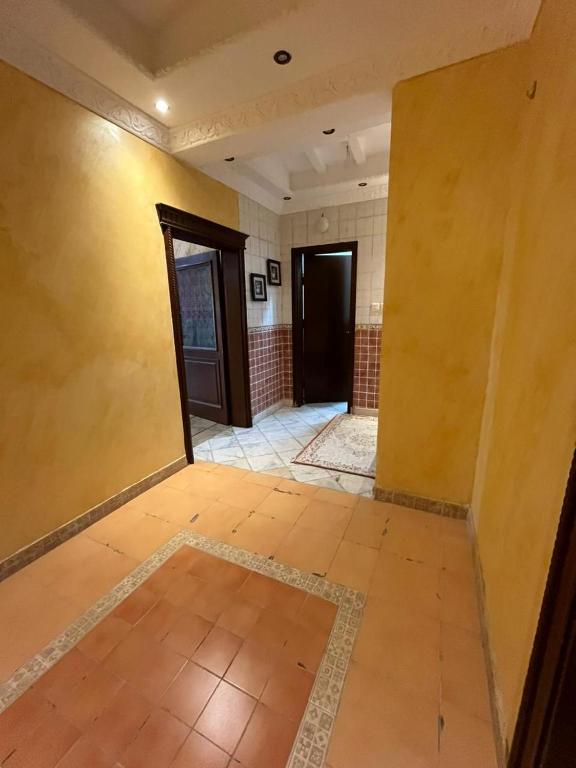 un couloir vide avec deux portes et du carrelage dans l'établissement فيلا دورين وملحق, à Muná