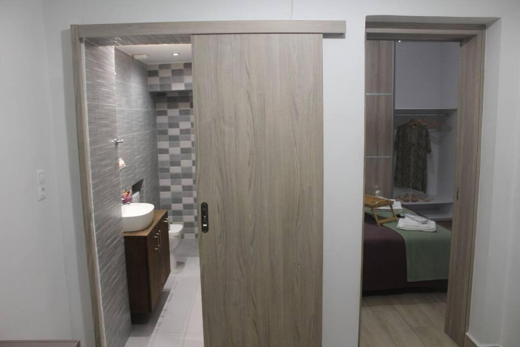 een badkamer met een deur naar een badkamer met een wastafel bij Ranias's House 2 in Piraeus