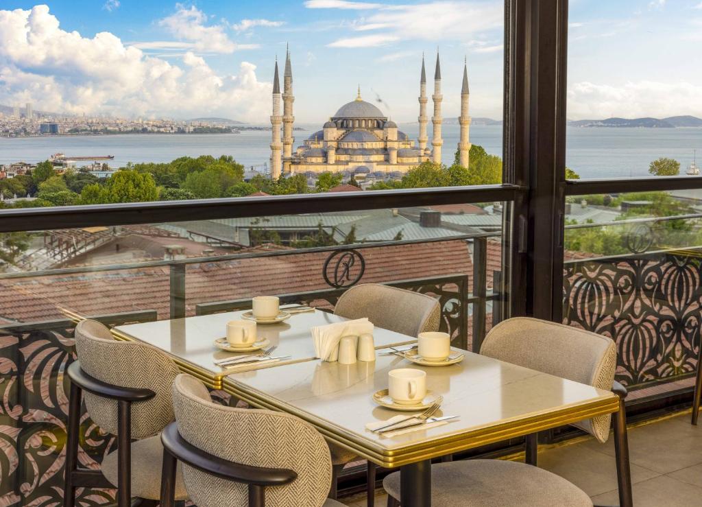 una mesa y sillas en un balcón con vistas a una mezquita en Rast Hotel Sultanahmet, en Estambul