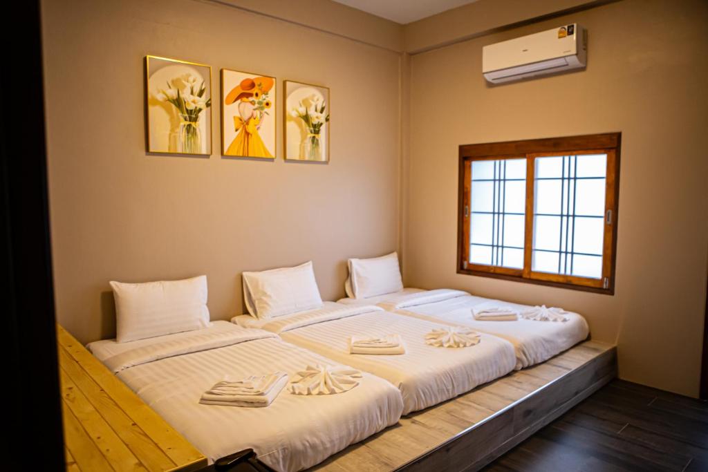 a bedroom with two beds with towels on them at Miki House in Chumphon