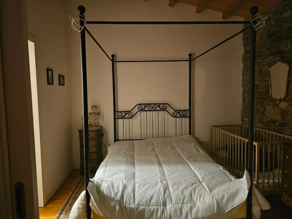 薩布加爾的住宿－Studio at Sabugal，一间卧室配有黑色天蓬床和白色床单