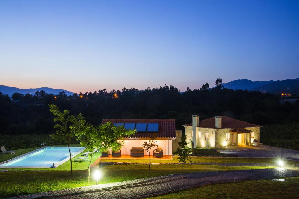 une villa avec une piscine la nuit dans l'établissement Quinta das Secas, à Arcos de Valdevez