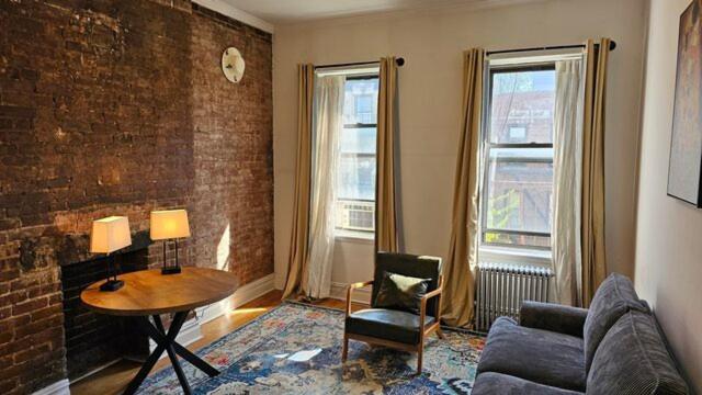 ein Wohnzimmer mit einem Sofa und einem Tisch in der Unterkunft Incentra Village Hotel in New York