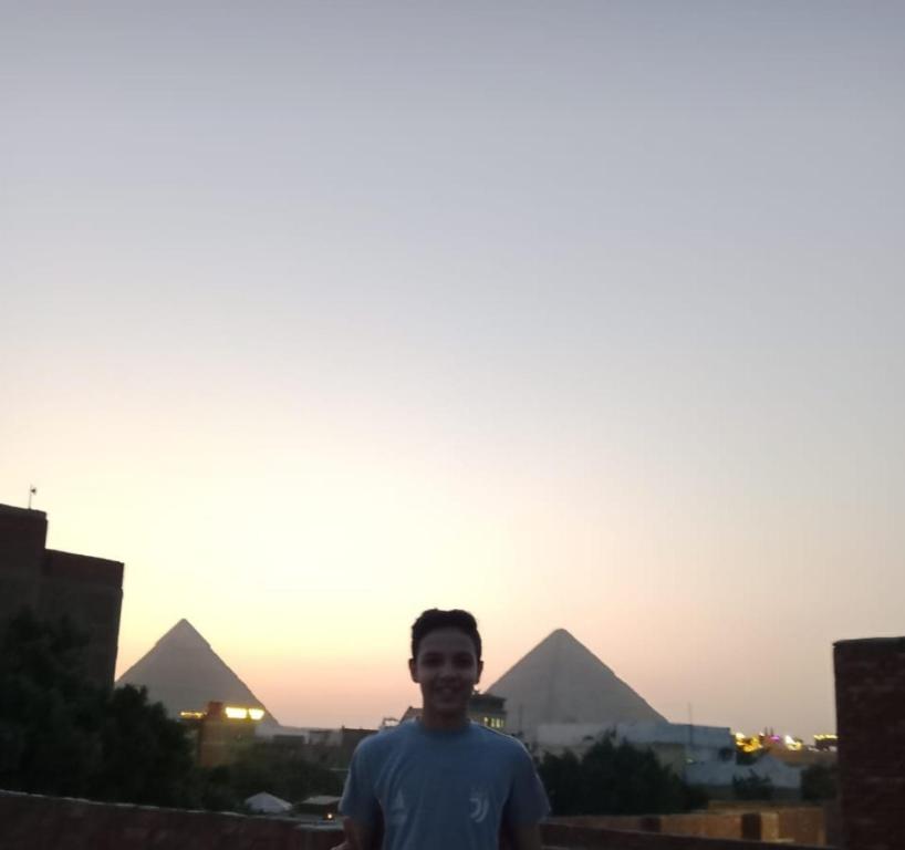 człowiek stojący przed piramidami w obiekcie Nana Pyramids Guest House w Kairze