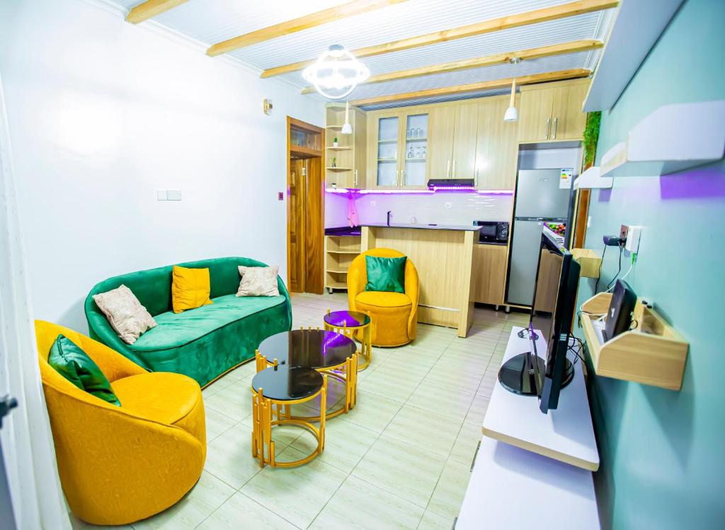 ein Wohnzimmer mit einer grünen Couch und gelben Stühlen in der Unterkunft Guest Suite in Kigali in Kigali