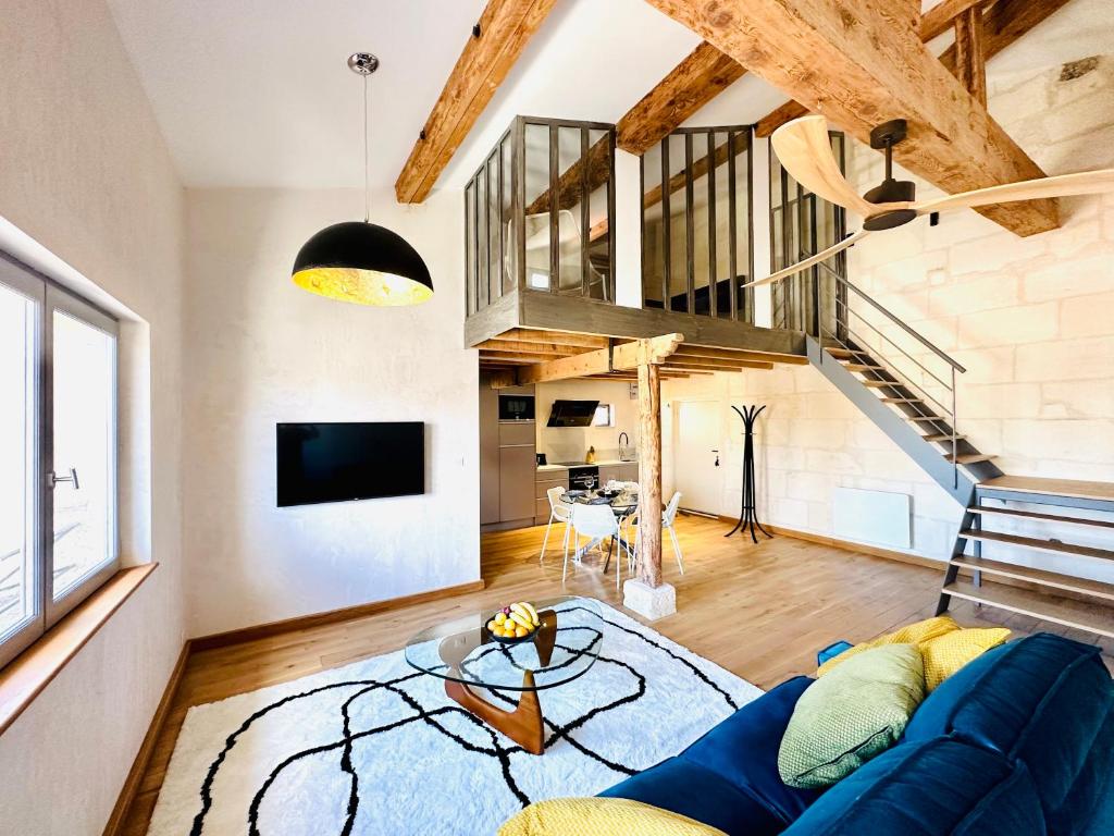 - un salon avec un canapé bleu et un escalier dans l'établissement Appartement en hyper centre d'Arles, à Arles