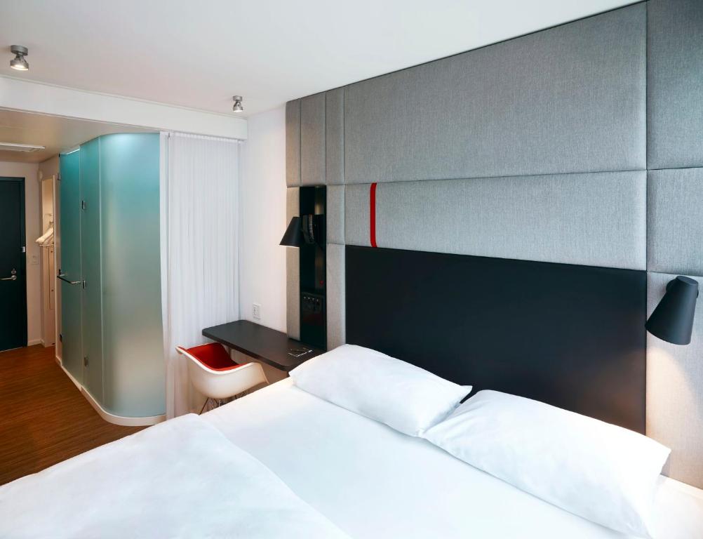 a bedroom with a white bed and a blue wall at citizenM Miami South Beach in Miami Beach