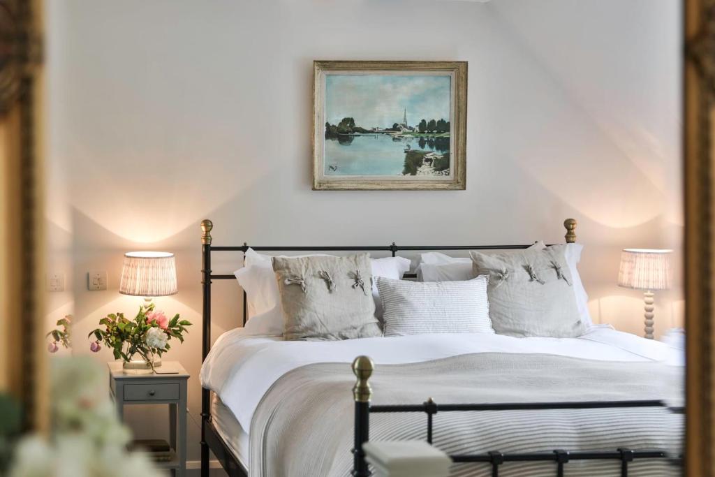 ein Schlafzimmer mit einem Bett mit weißen Laken und Kissen in der Unterkunft Cotswold Luxury Coach House - ideal for couples, w/ EV charging in Andoversford