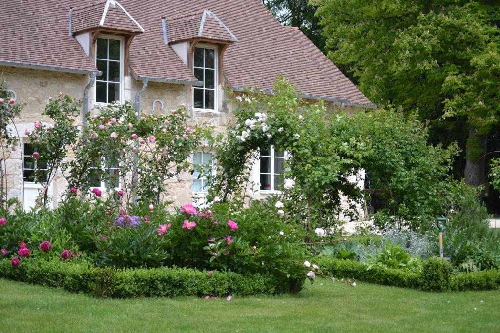 una casa con un jardín de flores delante de ella en La Maison du Potager de Mazières, en Sainte-Solange