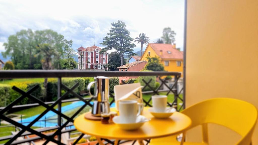 a table with two cups on a balcony with a view at El Rincon de las Americas in Colombres