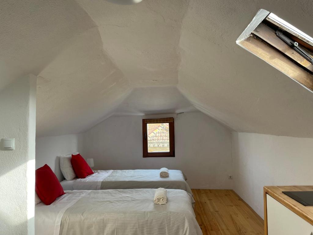 a bedroom with two beds in a attic at Casa do Cristo Rei I in Almada