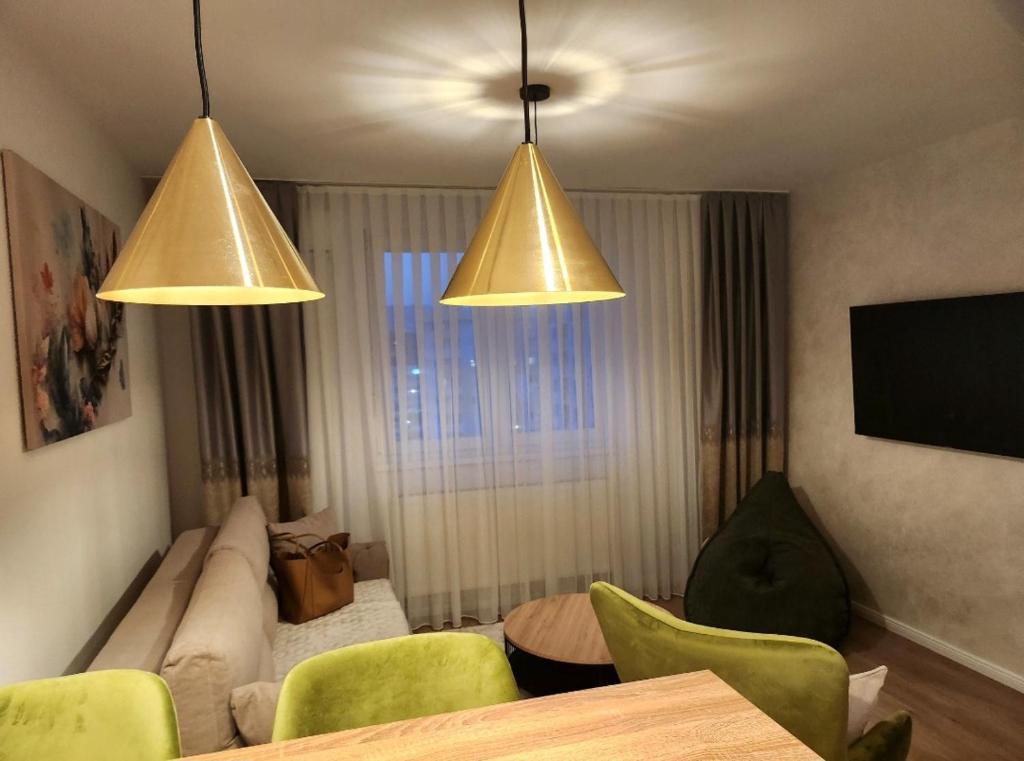 - un salon avec deux lumières, une table et des chaises dans l'établissement Apartman MK, à Lukavica