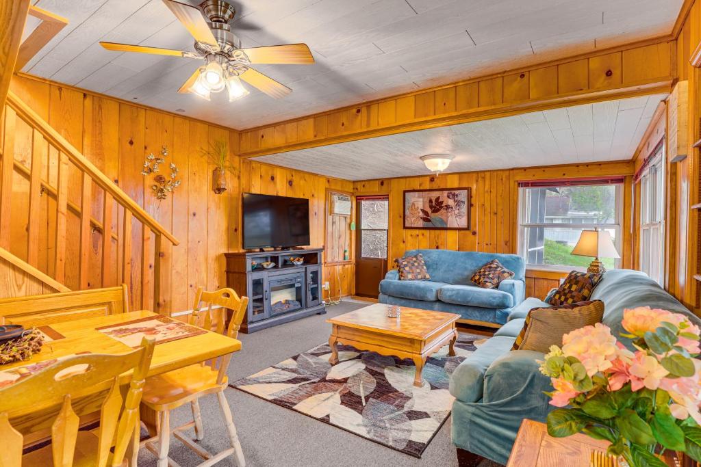 ein Wohnzimmer mit einem Sofa und einem Tisch in der Unterkunft Cozy Wisconsin Cabin Walk to Beach and Boat Ramp! in McGregor