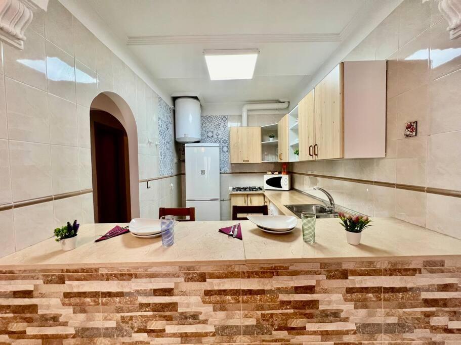 Una cocina con una mesa con platos encima. en VUT Bajo Castillo, en La Iruela