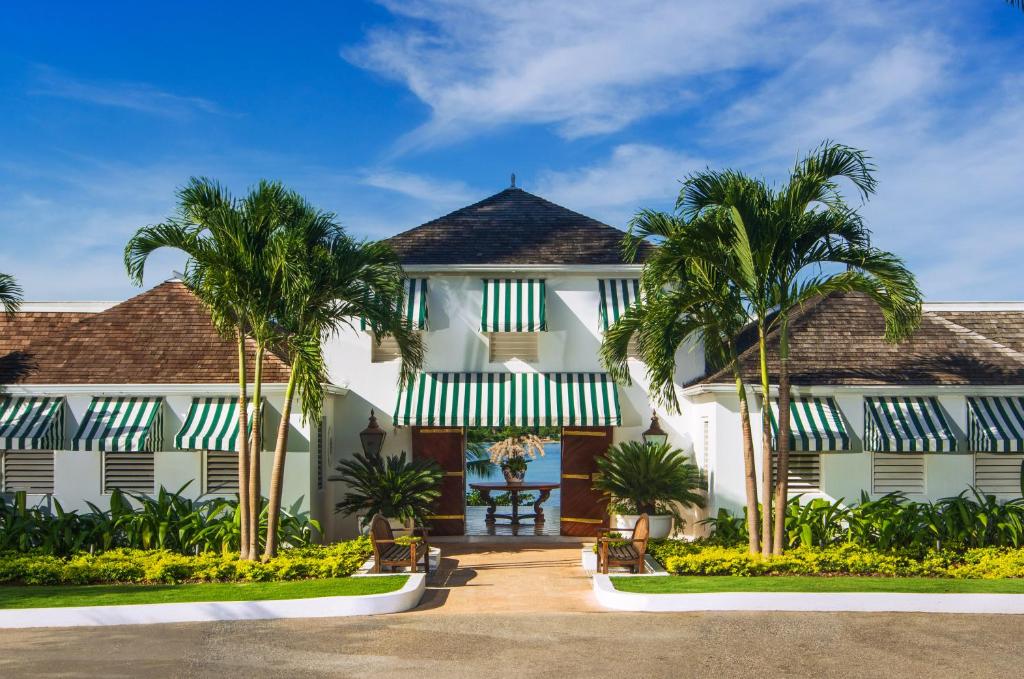 una casa con palmeras delante en Round Hill Hotel & Villas, en Montego Bay