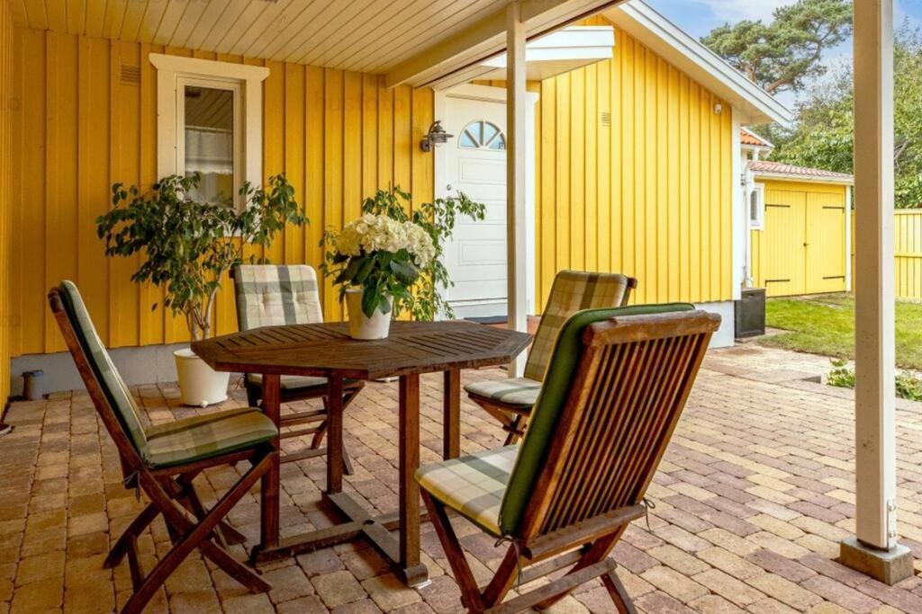 ハルムスタッドにあるTylösand guesthouse 300m from ocean & golf courseの木製テーブルと椅子付きのパティオ