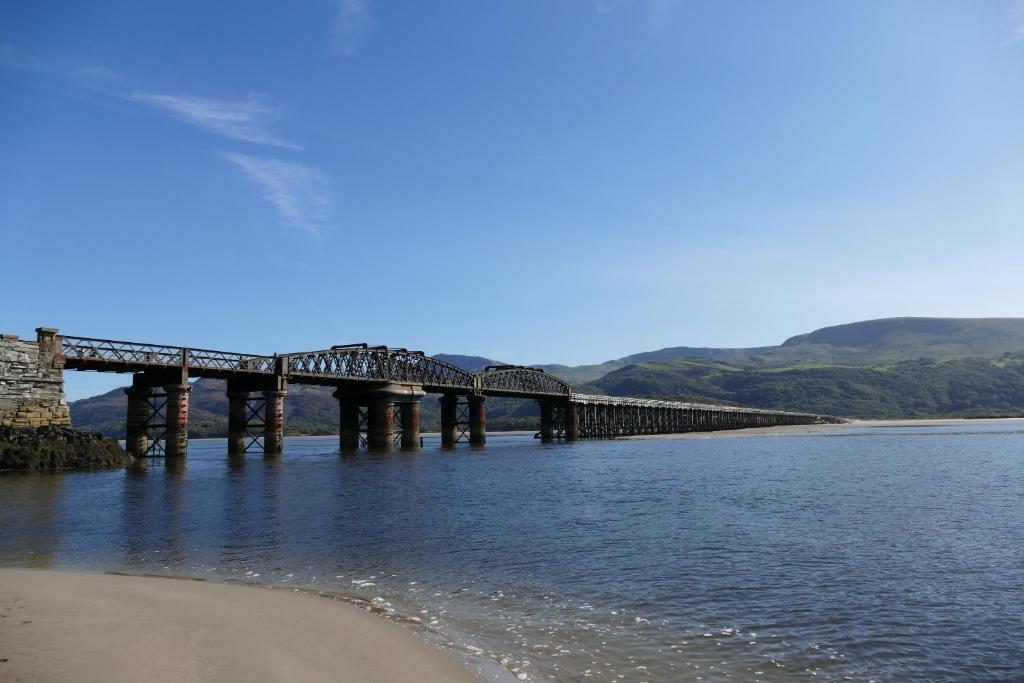 a bridge over the water next to a beach at Bae Abermaw Boutique B&B in Barmouth