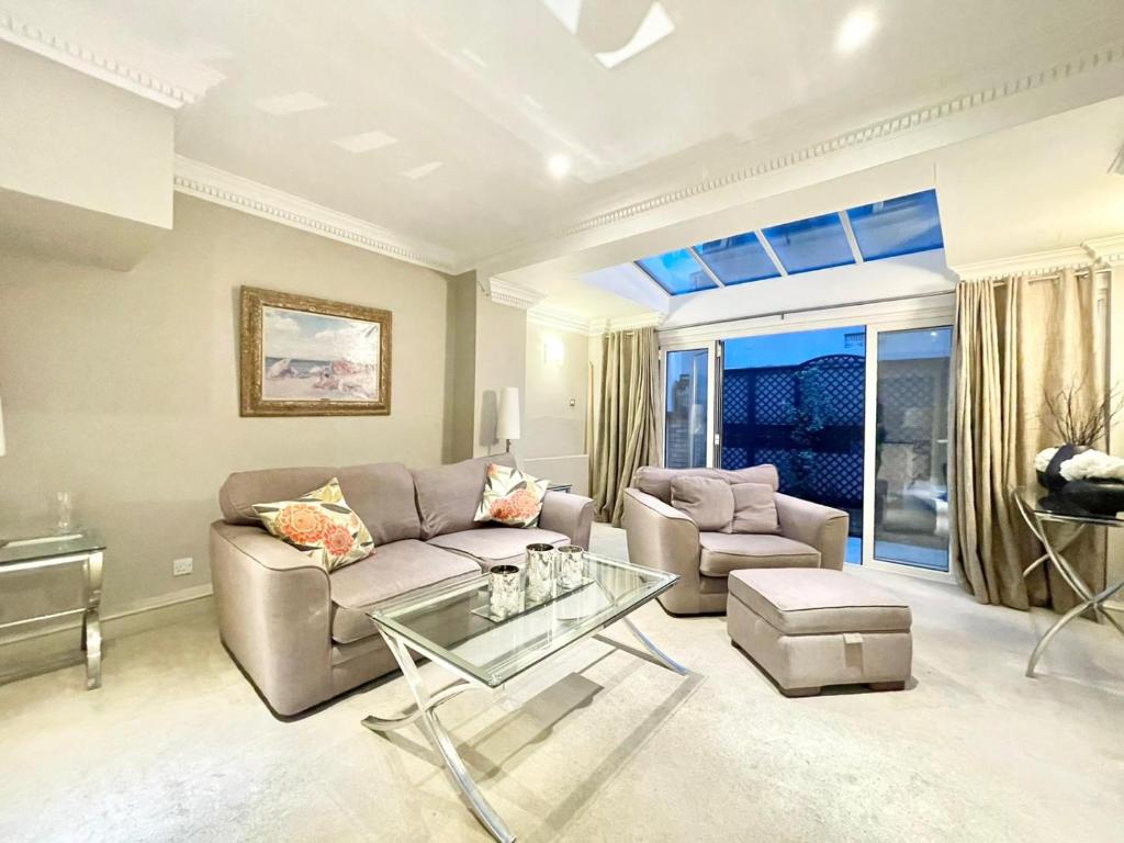 uma sala de estar com um sofá e uma mesa em Mayfair 2 Bedroom With Large Private Terrace em Londres