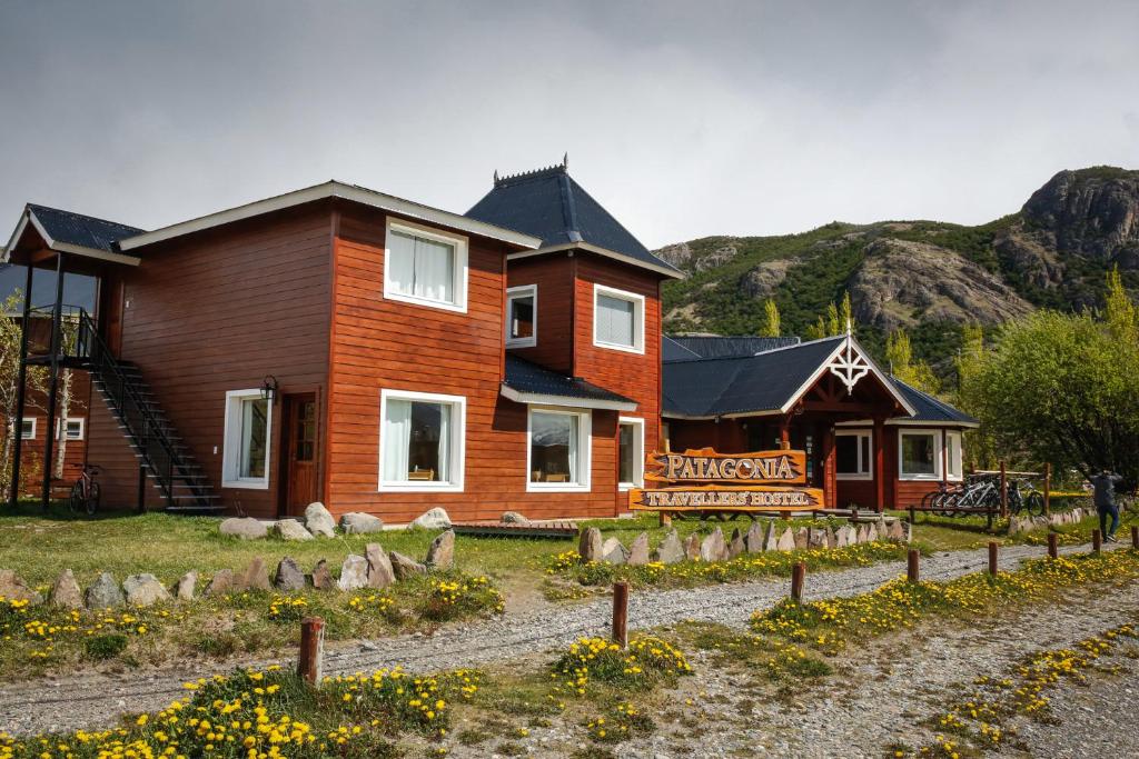 a wooden house with a sign in front of it at Patagonia Hostel in El Chalten