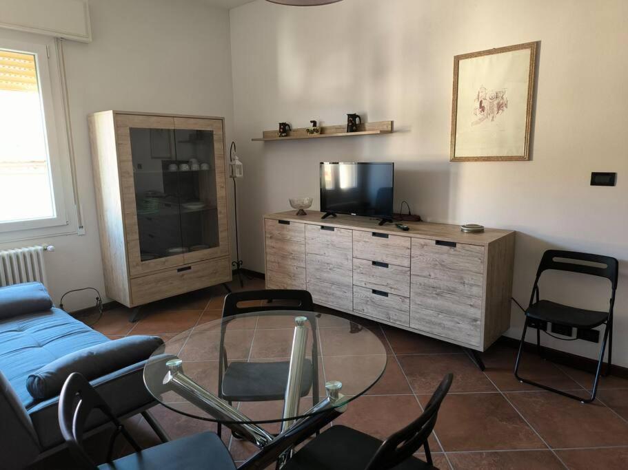 a living room with a tv and a glass table at Appartamento nuovo e delizioso in Vidiciatico